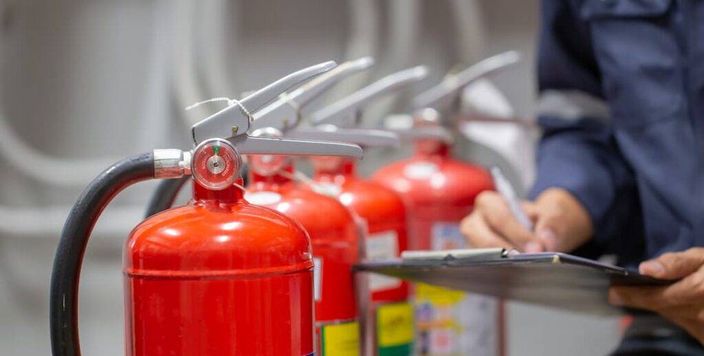 man checking fire extinguishers for fire safety